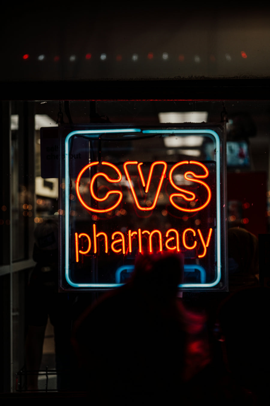 A neon cvs pharmacy sign glows at night.