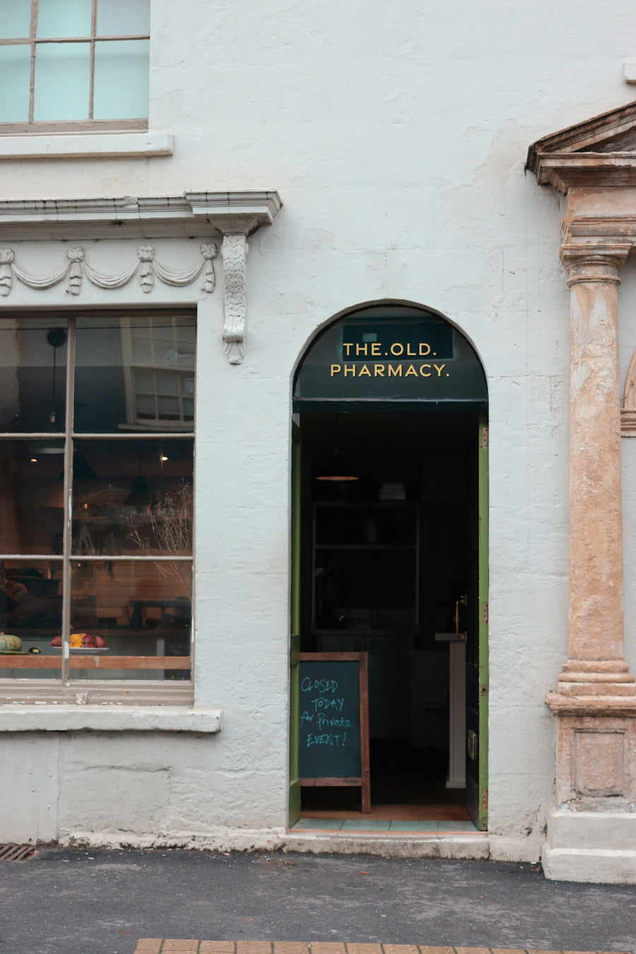 Entrance to the old pharmacy with a chalkboard sign.