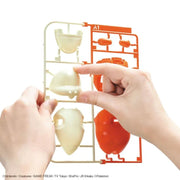 Bandai Fuecoco Pokémon model kit parts being removed by hand for snap assembly